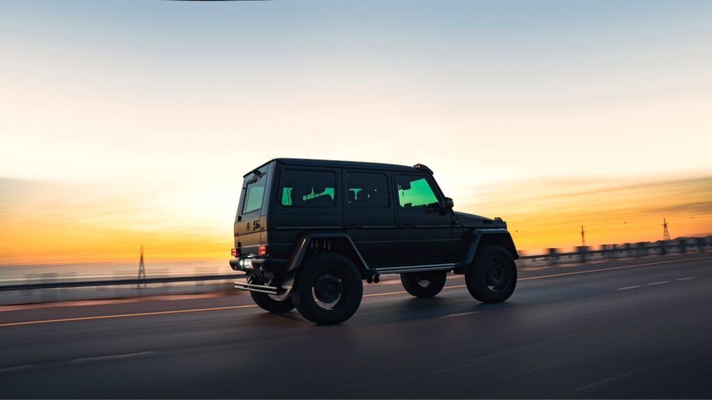 voiture jeep qui roule sur une route avec le soleil couchant