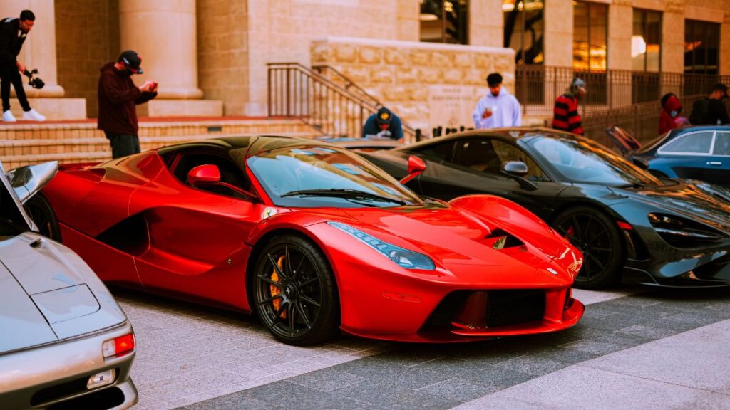 Voiture de sport rouge garée à côté d'autres voitures de sport