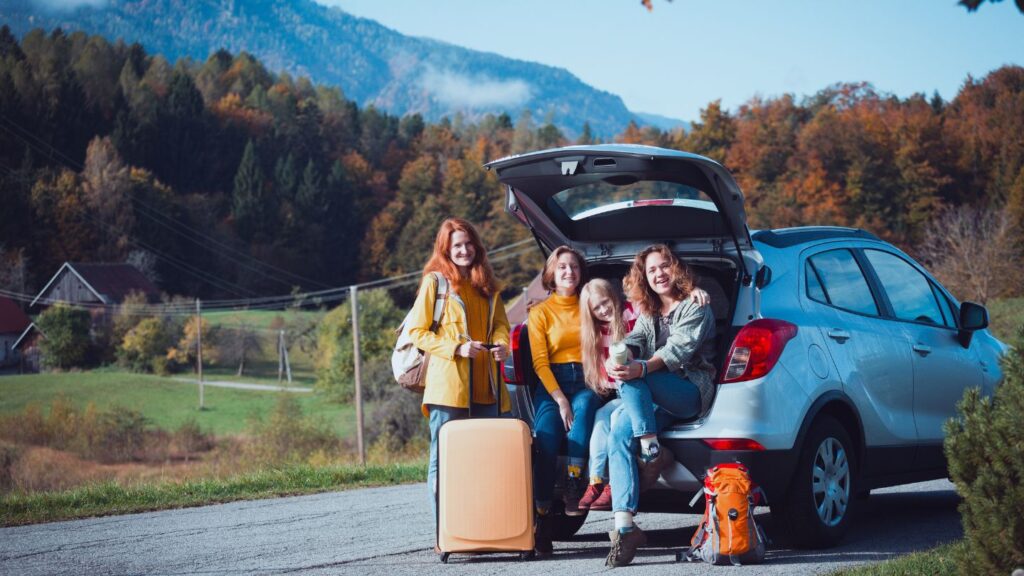 famille assise à l'arriere d une voiture route de campagne